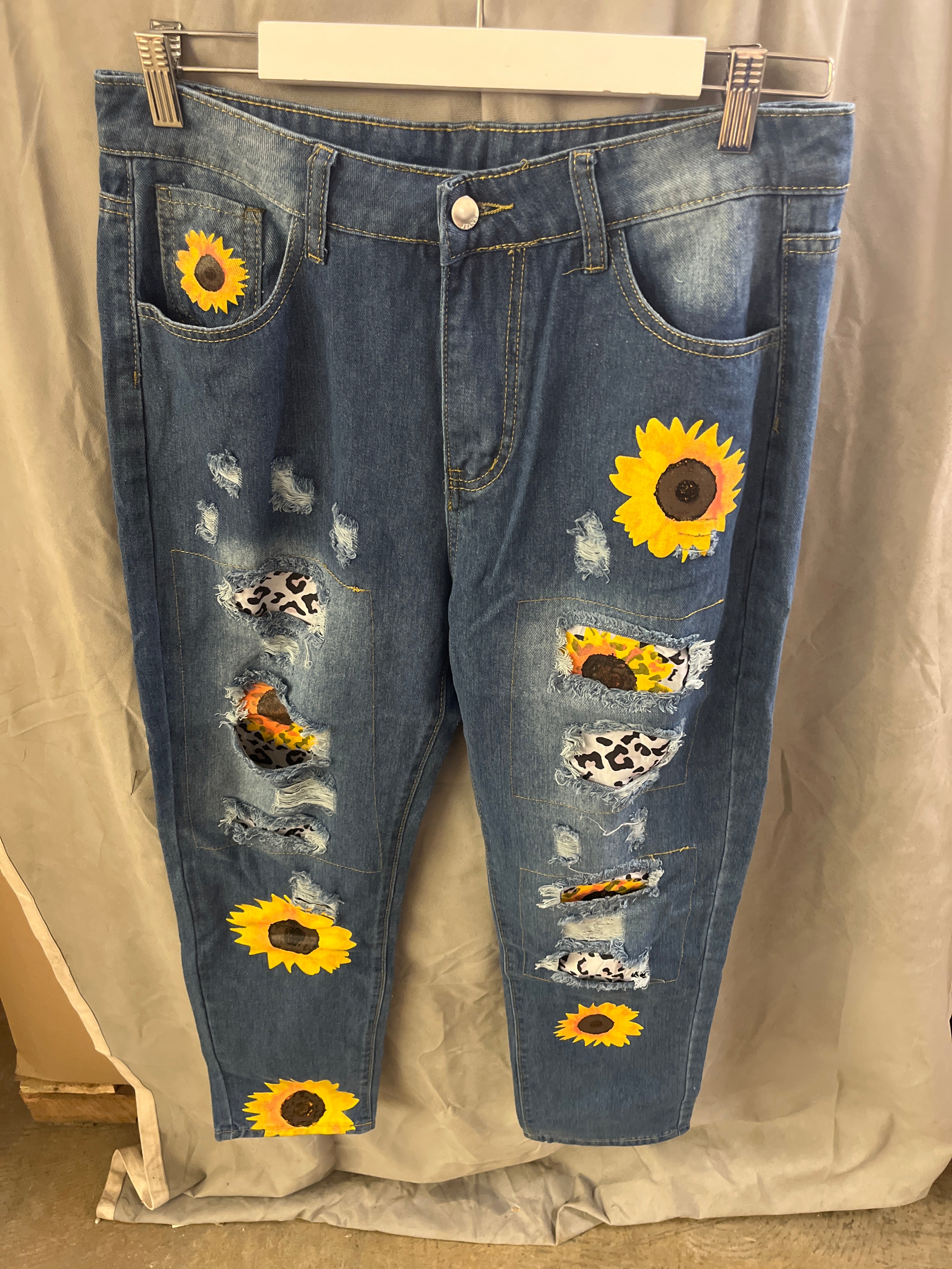 Blue ripped jeans with sunflower designs